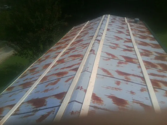 Rusted metal roof panels with new wood purlins before replacement — Storm Damage Roof Repair in Scipio Center by Roofing Brothers