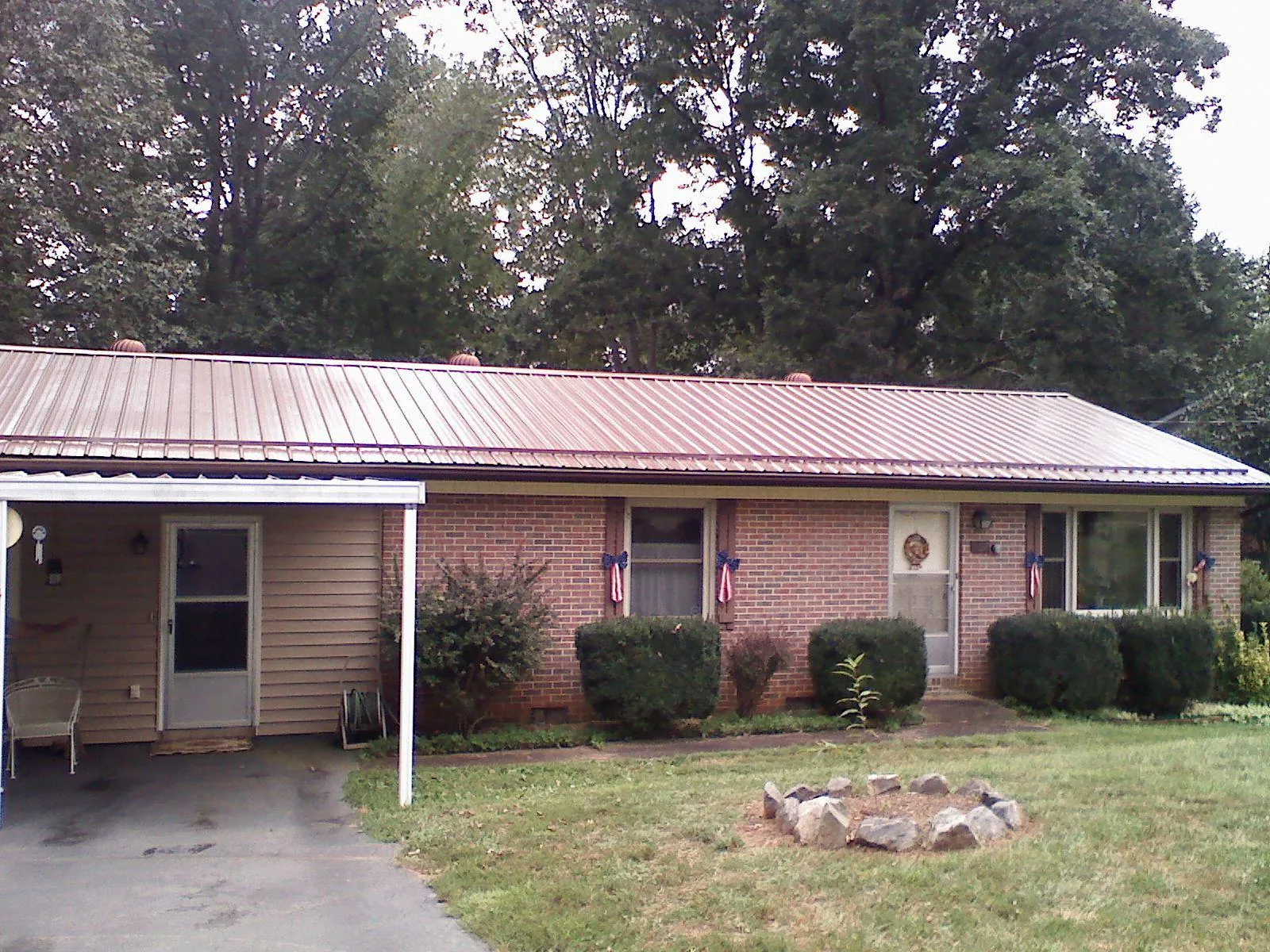 Bronze metal roof and carport on a brick ranch home — Roof Repair work by our crew in Scipio Center